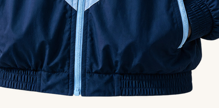 The elastic hem and panel seam of the V Chevron Windbreaker